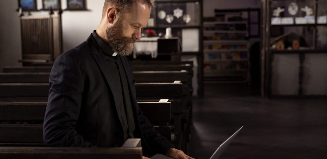 gros plan sur un pretre a l aide d un ordinateur portable